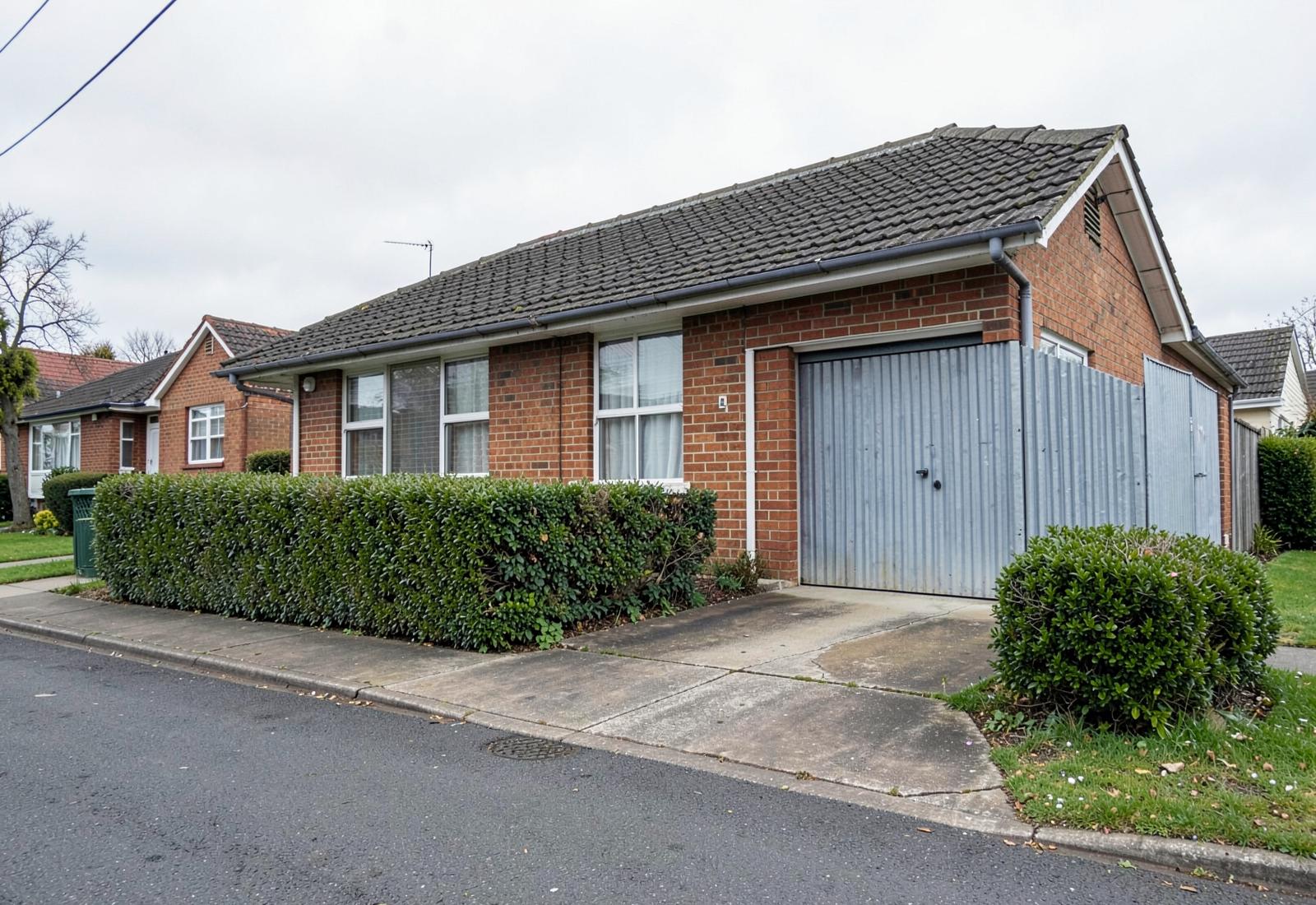 A brick and tile Christchurch unit with a corrugated iron garage, mid do up